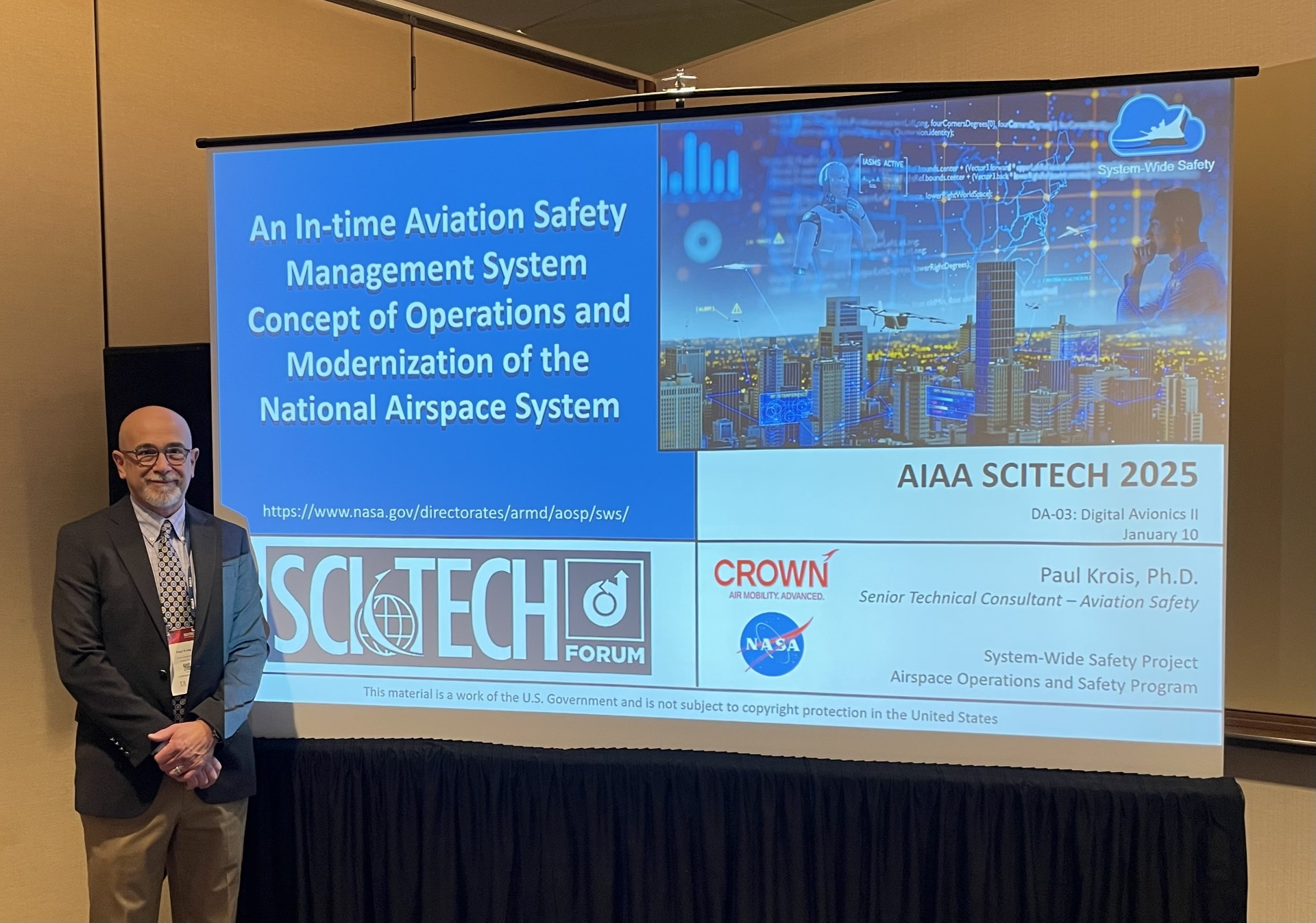 Dr. Paul Krois stands next to a large display showing the first slide of his presentation.